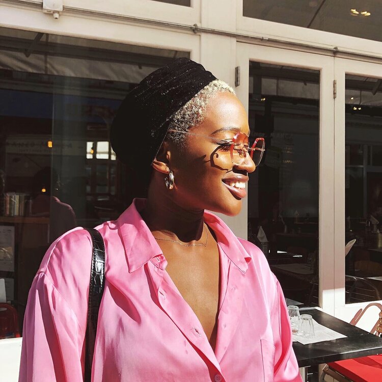 Colour image of Ebiye Beedie in pink shirt with pink rimless glasses